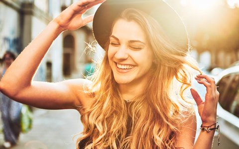 Smiling woman with a hat has straight teeth from orthodontics in Boulder