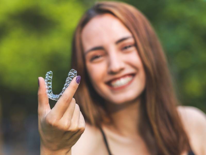 Girl holding clear aligner