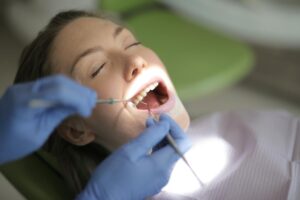 A young woman getting her teeth examined by her dentist after a root canal in Boulder.