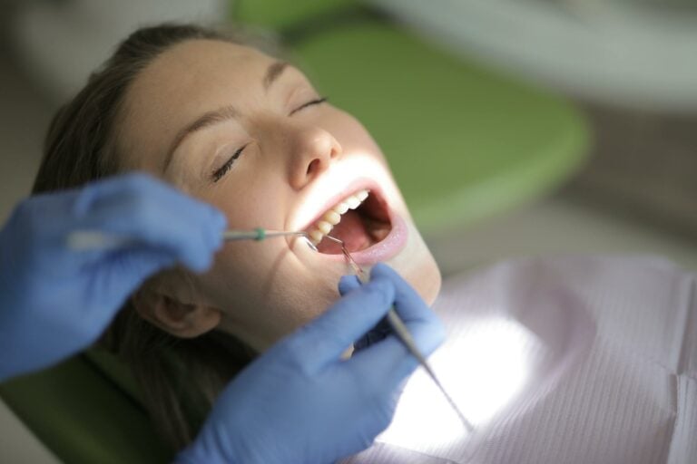 A young woman getting her teeth examined by her dentist after a root canal in Boulder.