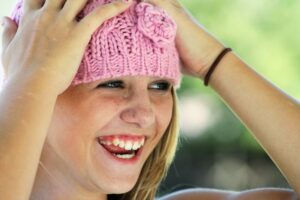A girl in a pink hat, rested after sleep apnea treatment for children in Boulder.