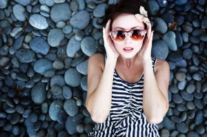 A young woman reclining on a stone beach, free of headaches from TMJ in Boulder.